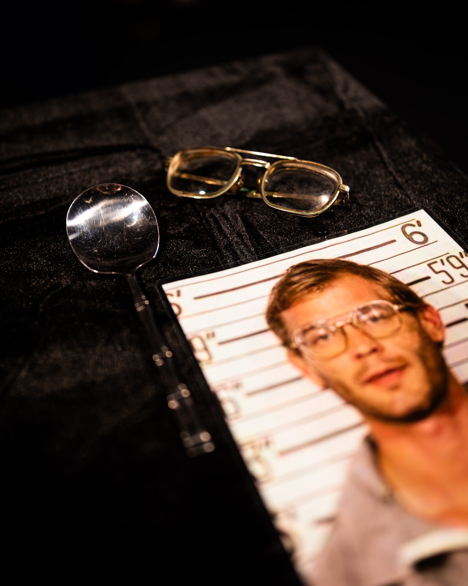 Jeffrey Dahmer's authenticated eyeglasses resting on his 1991 booking photo